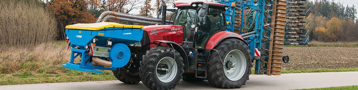 Kunde Moser Bild eines roten Case Traktor mit blauem Mähgerät
