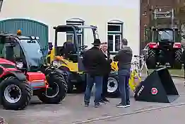 Bild von zwei Herren die an einem gelben Traktor stehen